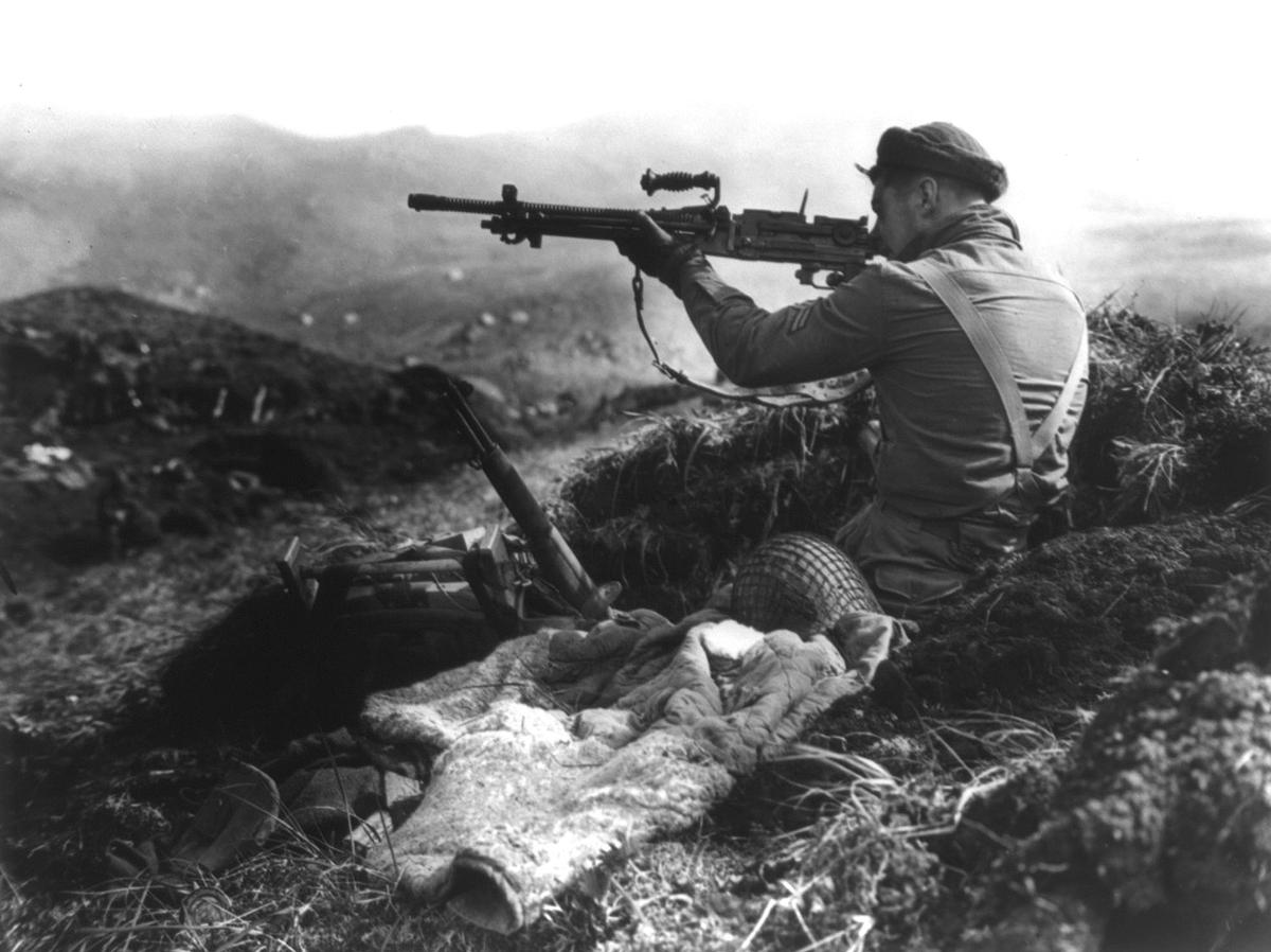 Canadian soldier aiming at a Japanese trench, Kiska 1943